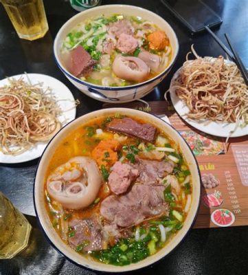  Bún Bò Huế: ¡Un plato vibrante que combina la frescura de hierbas aromáticas con la intensidad del caldo picante!